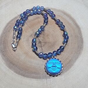 blue opalescent  glass bead necklace with a moon goddess face pendant